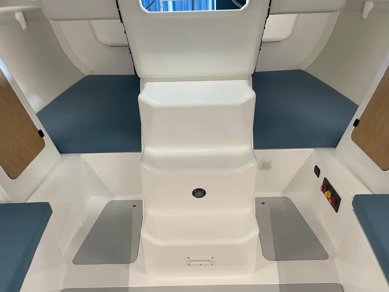 Slide: The Image of Interior of 2024 M.A.T. 1070 sailboat with blue cushions and white steps. - 16