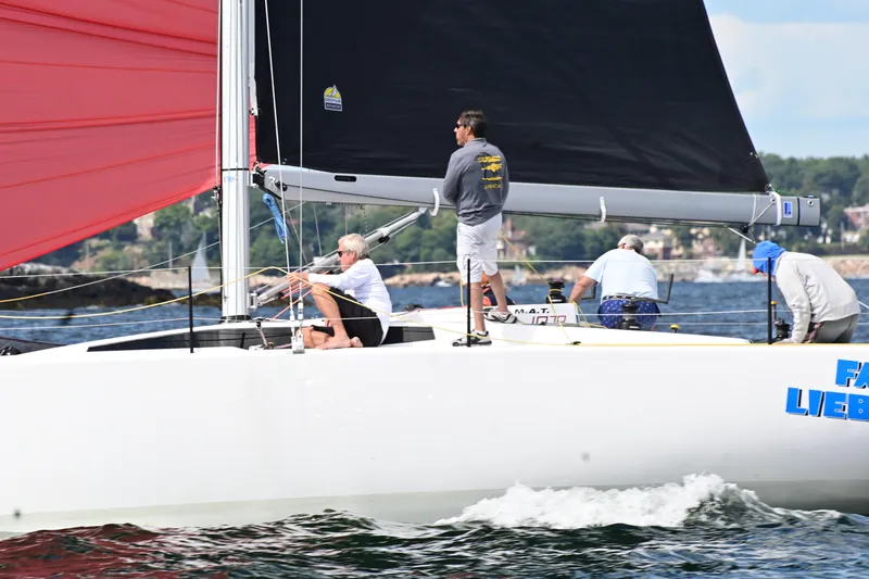 Slide: The Image of Sailing on M.A.T. 1070 yacht, 2024 model, with vibrant red and black sails. - 19