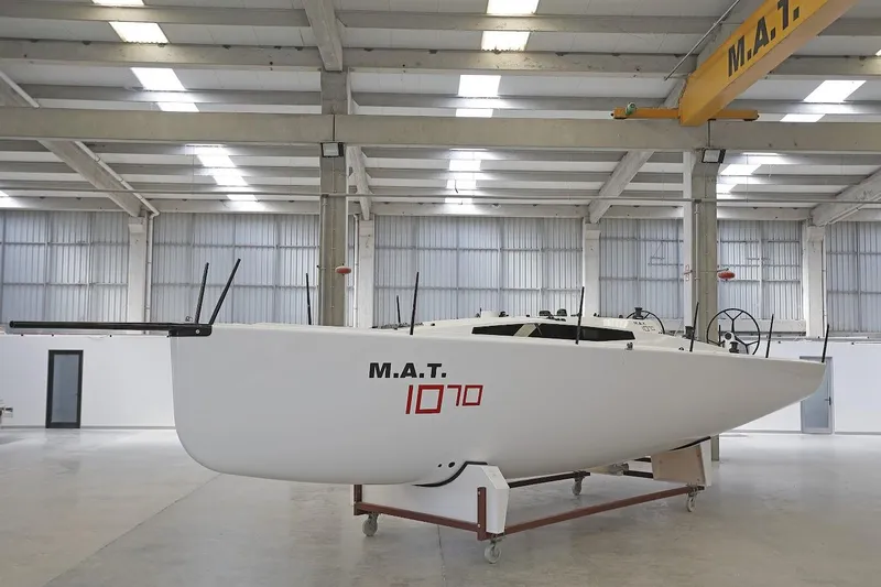 Slide: The Image of 2024 M.A.T. 1070 sailboat in a modern indoor facility. - 4