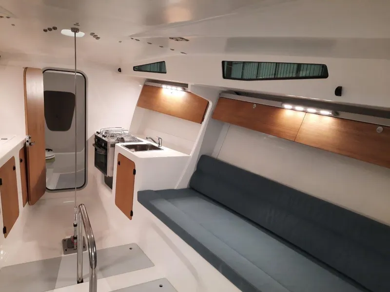 Slide: The Image of 2024 M.A.T. 1070 yacht interior with modern kitchen, seating area, and wooden accents. - 6