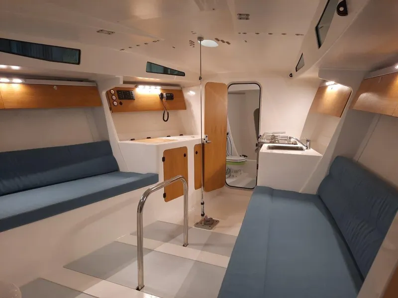 Slide: The Image of Modern interior of M.A.T. 1070 sailboat, 2024 model, featuring blue seating and wooden accents. - 9
