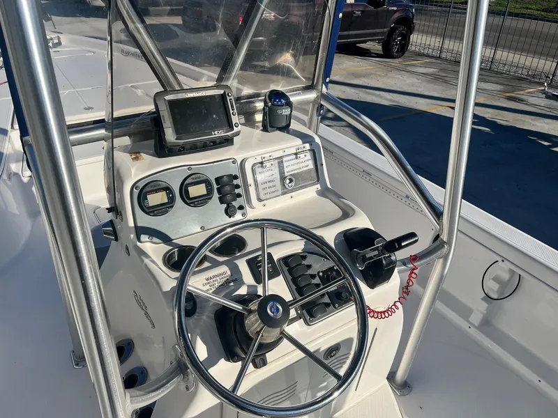 Slide: The Image of 2011 Blue Wave Pure Bay 2400 boat console with steering wheel and navigation equipment. - 8