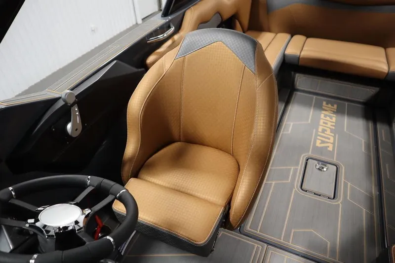 Slide: The Image of 2024 Supreme ZS232 boat interior with tan and black seating, steering wheel, and Supreme logo. - 39