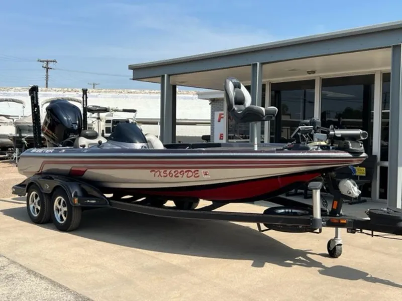 Slide: The Image of 2014 Skeeter 20i boat interior with steering wheel and control panel in parking lot. - 16