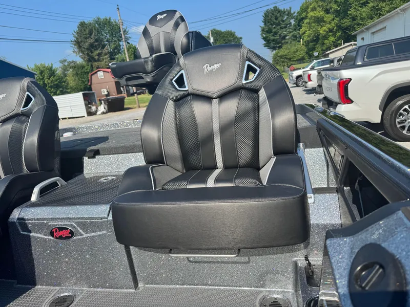 Slide: The Image of 2024 Ranger Z521R CUP boat with black and gray seats in a parking lot. - 11