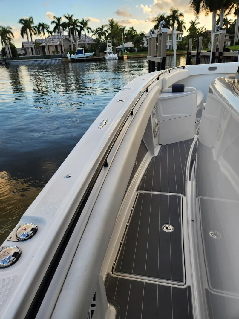 Slide: The Image of 2019 HCB 39 Speciale boat docked by waterfront homes, palm trees in background. - 34
