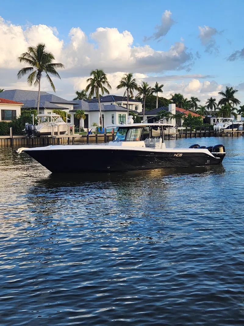 Slide: The Image of 2019 HCB 39 Speciale boat cruising near waterfront homes with palm trees. - 9