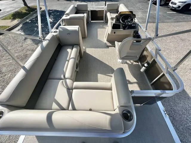 Slide: The Image of 2024 Avalon VTX 19 Cruise pontoon boat interior with beige seating and steering console. - 16