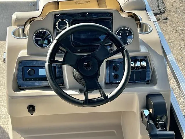 Slide: The Image of 2024 Avalon VTX 19 Cruise boat dashboard with steering wheel and control panel. - 21