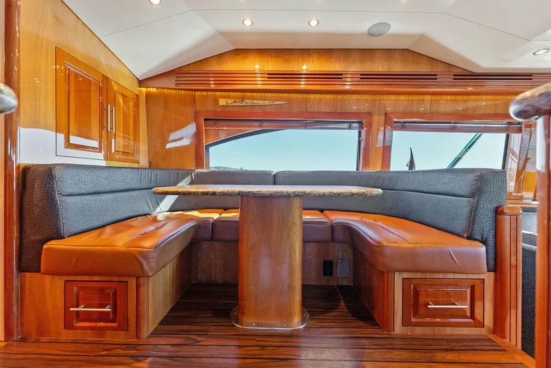 Slide: The Image of Luxurious interior of a 2007 Hatteras 64 Convertible yacht with wooden finishes and leather seating. - 11
