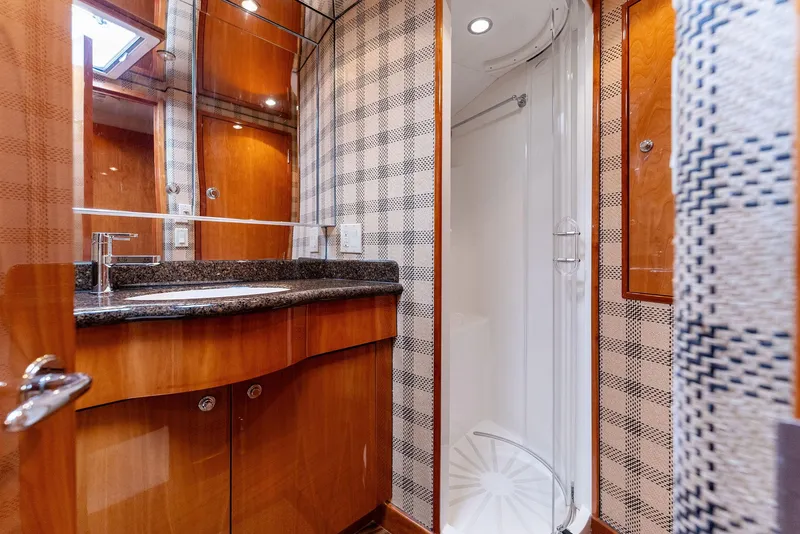 Slide: The Image of Luxurious bathroom in a 2007 Hatteras 64 Convertible yacht with wood cabinetry and modern fixtures. - 19