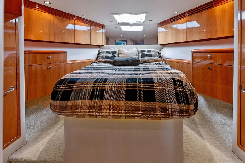 Slide: The Image of Luxurious bedroom in 2007 Hatteras 64 Convertible yacht with wood cabinetry and plaid bedding. - 2