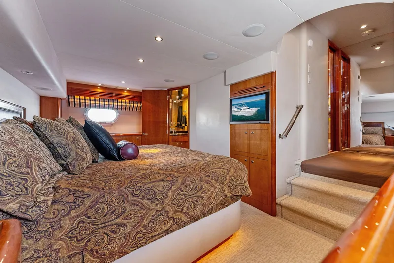 Slide: The Image of Luxurious bedroom interior of 2007 Hatteras 64 Convertible yacht with elegant bedding and wooden accents. - 27