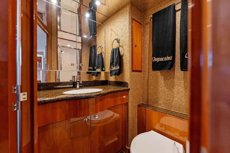 Slide: The Image of Luxurious bathroom in a 2007 Hatteras 64 Convertible yacht with wood cabinetry and granite countertop. - 29