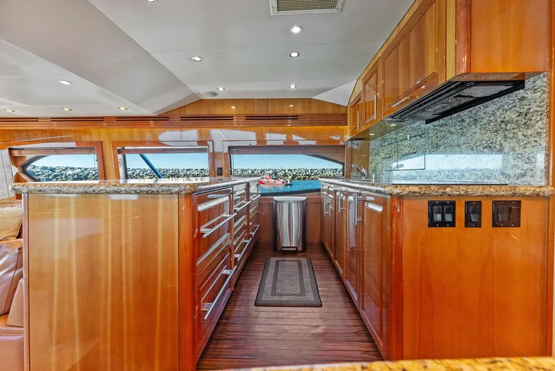 Slide: The Image of Luxurious kitchen interior of 2007 Hatteras 64 Convertible yacht with wooden cabinetry and granite countertops. - 9