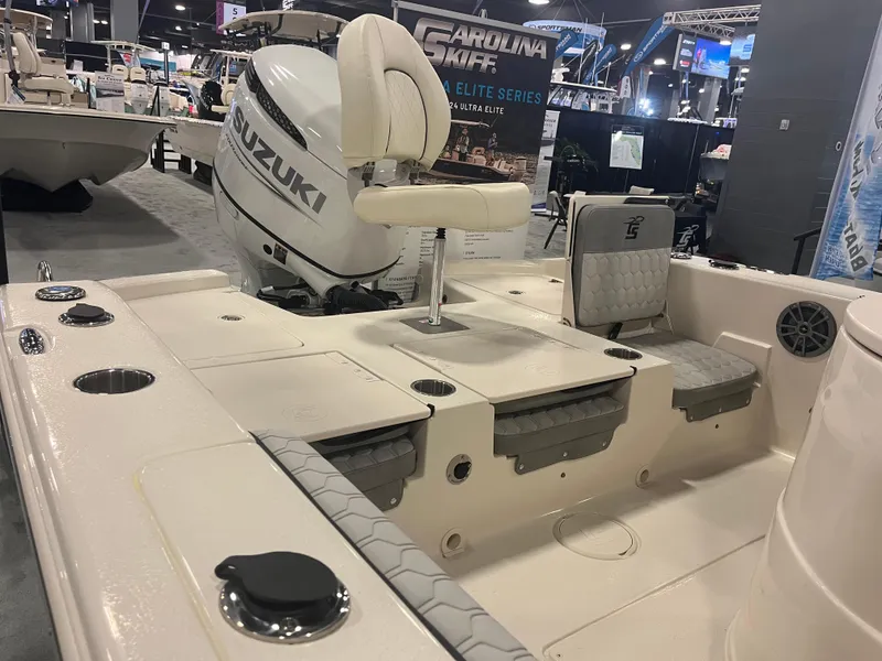 Slide: The Image of 2024 Carolina Skiff 24 Ultra Elite boat interior with Suzuki outboard motor at a boat show. - 21