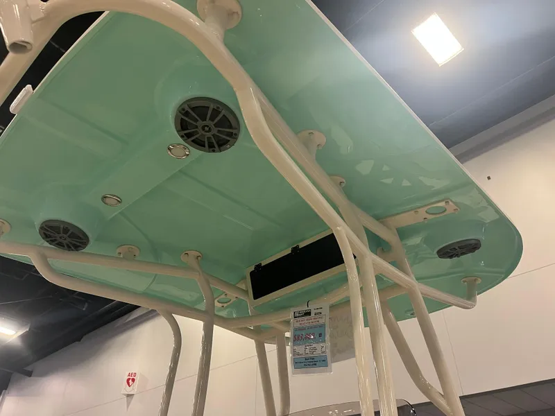 Slide: The Image of 2024 Carolina Skiff 24 Ultra Elite boat with teal T-top and built-in speakers. - 23