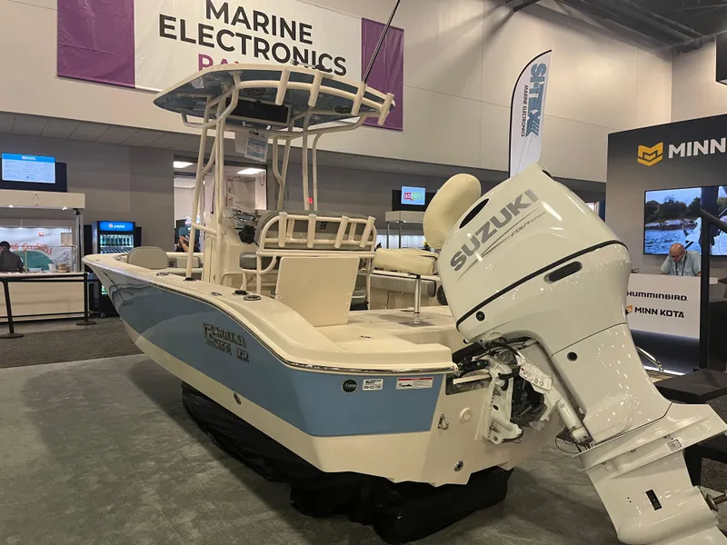 Slide: The Image of 2024 Carolina Skiff 22 Ultra Elite boat with Suzuki outboard motor at a marine electronics expo. - 10