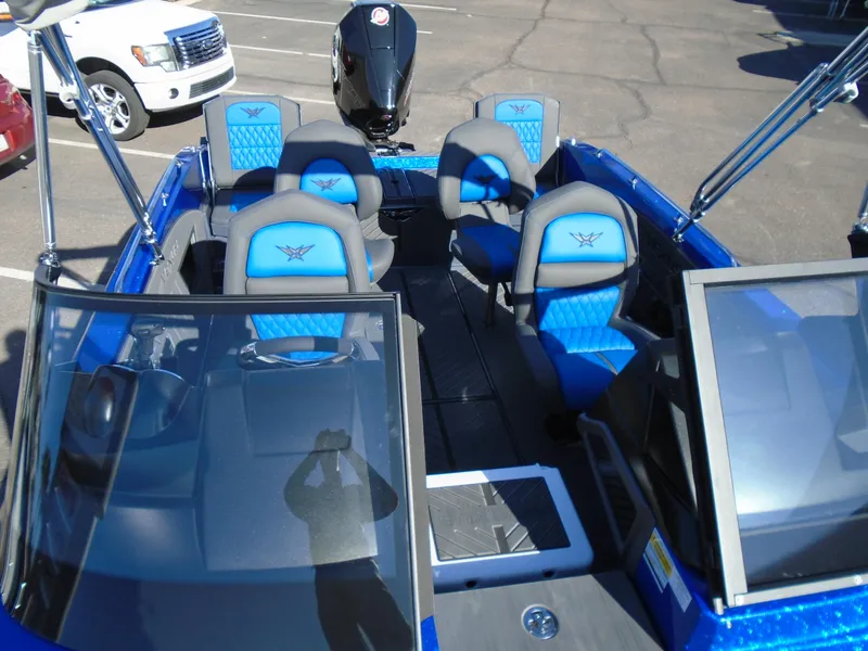 Slide: The Image of 2024 Vexus DVX20S boat with blue and gray seating in a parking lot. - 18