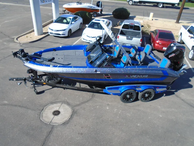Slide: The Image of 2024 Vexus DVX20S boat in blue and black on a trailer in a parking lot. - 7