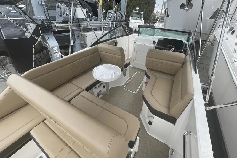 Slide: The Image of 2019 Sea Ray SDX 250 Outboard boat interior with tan seating and a small table. - 17