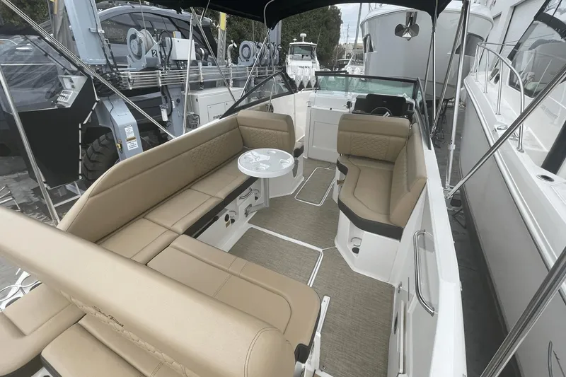 Slide: The Image of 2019 Sea Ray SDX 250 Outboard boat interior with tan seating and a small table. - 18