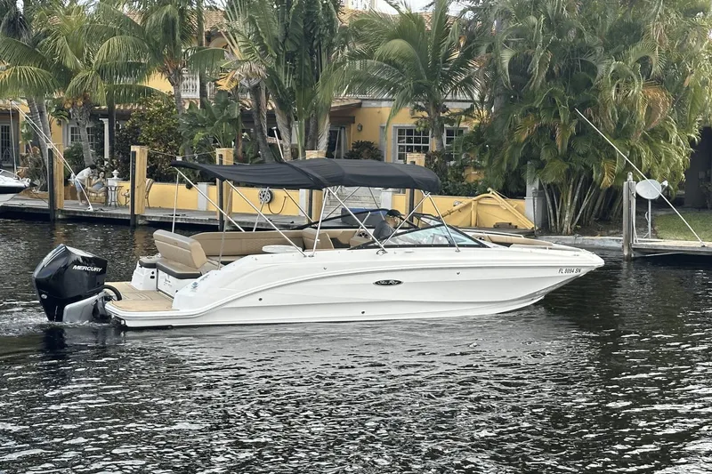 Slide: The Image of 2019 Sea Ray SDX 250 Outboard boat cruising on a canal with lush greenery. - 2