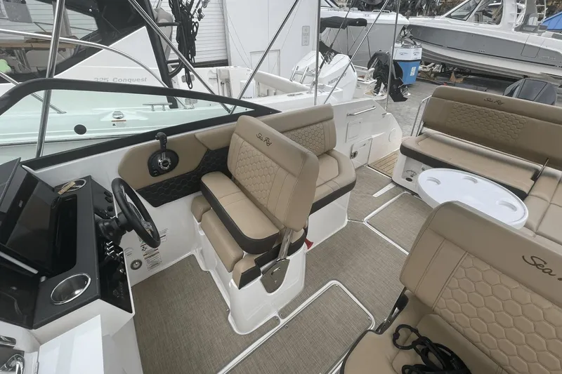 Slide: The Image of 2019 Sea Ray SDX 250 Outboard interior with beige seating and modern dashboard. - 20