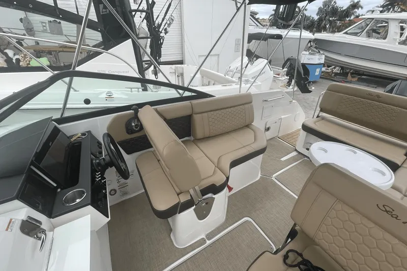 Slide: The Image of 2019 Sea Ray SDX 250 Outboard interior with beige seating and modern dashboard. - 21