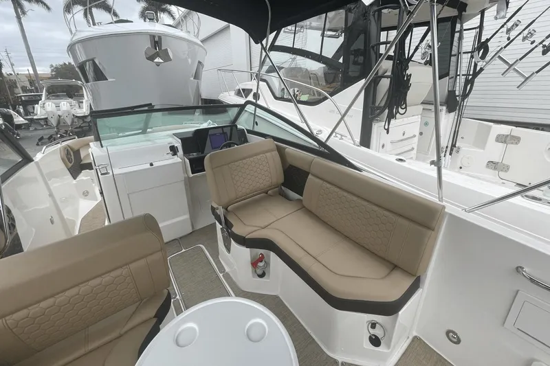 Slide: The Image of 2019 Sea Ray SDX 250 Outboard interior with tan seating and modern dashboard. - 22
