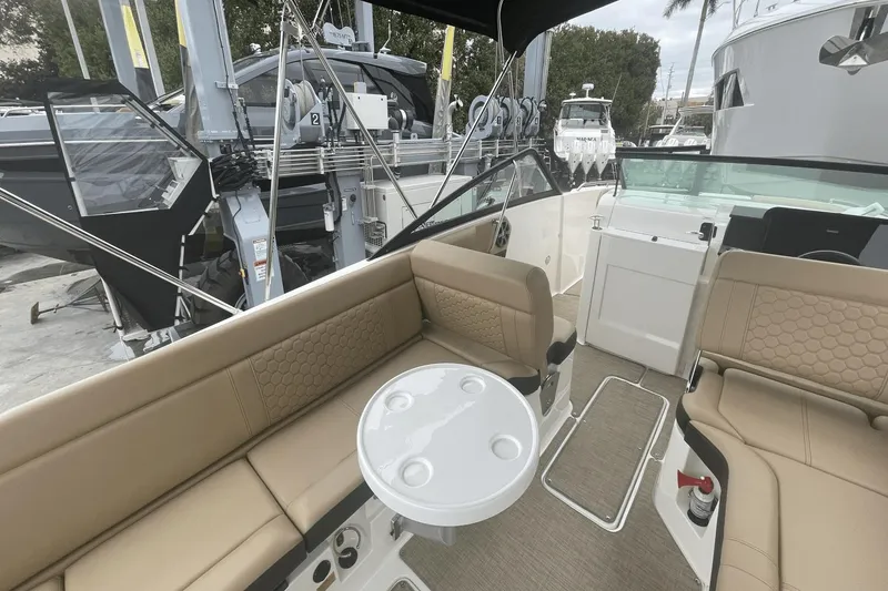 Slide: The Image of 2019 Sea Ray SDX 250 Outboard interior with tan seating and round table. - 23