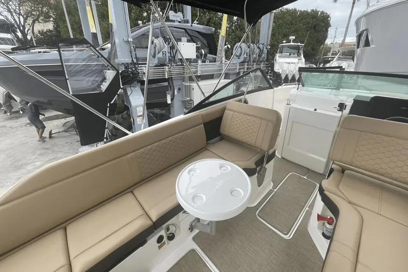 Slide: The Image of 2019 Sea Ray SDX 250 Outboard interior with tan seating and round table. - 24
