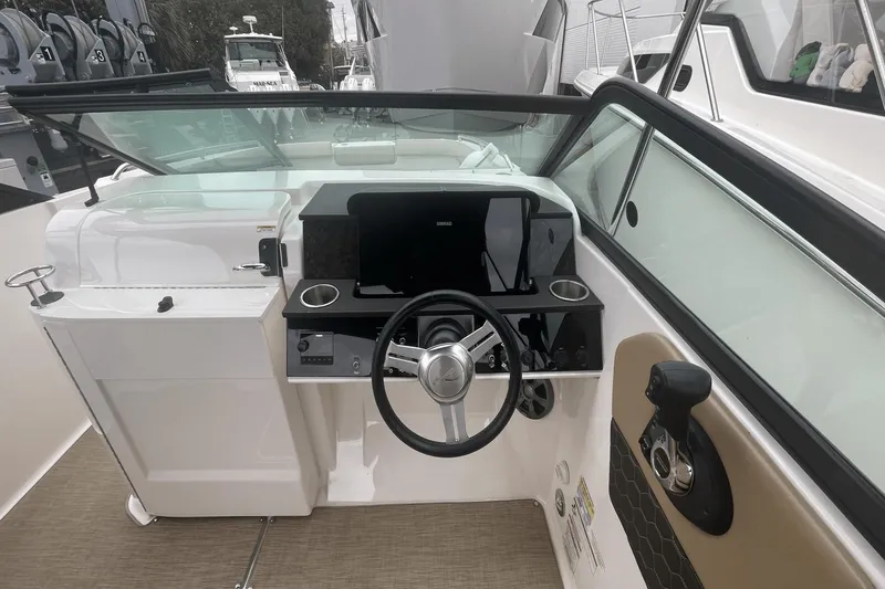 Slide: The Image of 2019 Sea Ray SDX 250 Outboard helm with steering wheel and control panel. - 25