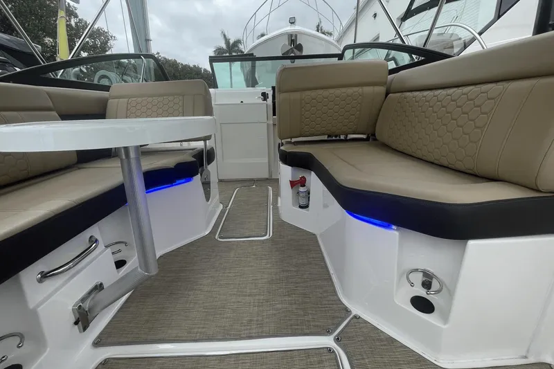 Slide: The Image of 2019 Sea Ray SDX 250 Outboard interior with beige seating and modern design. - 26