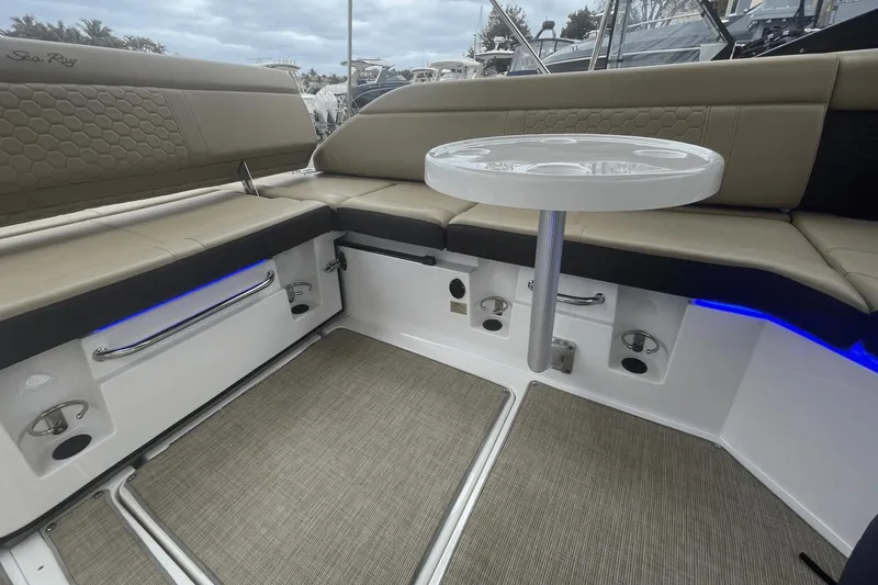 Slide: The Image of 2019 Sea Ray SDX 250 Outboard interior with beige seating and round table. - 27