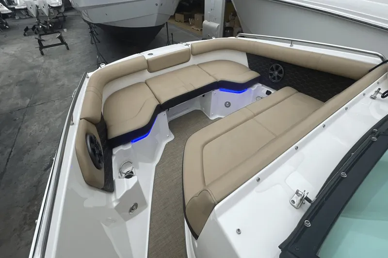 Slide: The Image of 2019 Sea Ray SDX 250 Outboard boat interior with beige seating and blue LED lighting. - 28