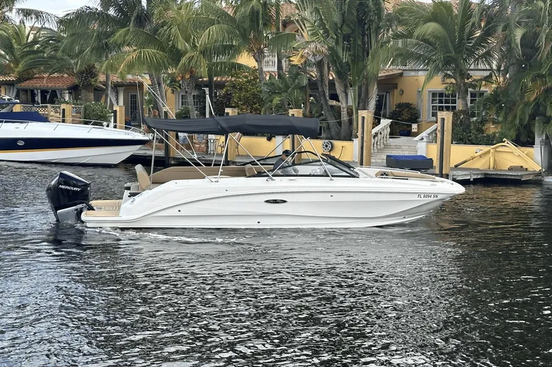 Slide: The Image of 2019 Sea Ray SDX 250 Outboard boat cruising on a canal near tropical waterfront homes. - 3