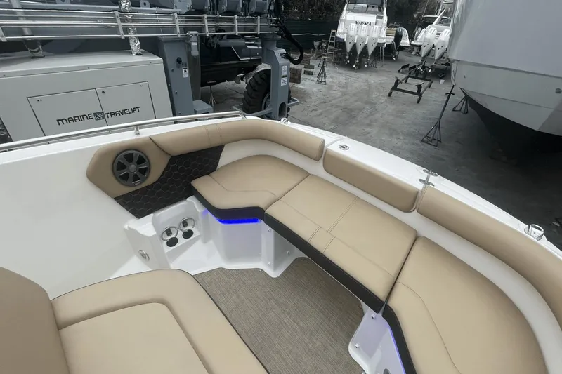Slide: The Image of 2019 Sea Ray SDX 250 Outboard boat interior with beige seating and blue accent lighting. - 30