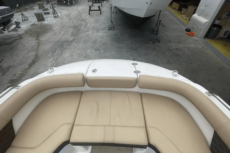 Slide: The Image of 2019 Sea Ray SDX 250 Outboard boat interior with beige seating in a workshop. - 33