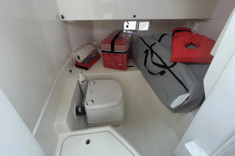 Slide: The Image of 2019 Sea Ray SDX 250 Outboard cabin with portable toilet and safety equipment. - 38