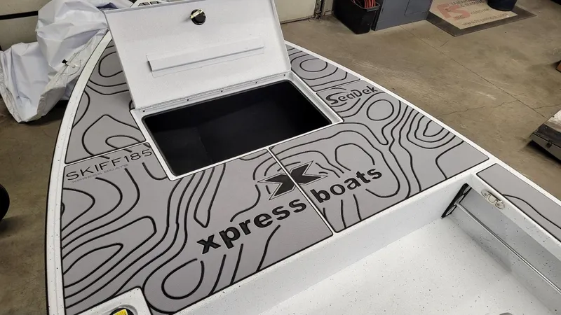 Slide: The Image of 2025 Xpress Skiff 185 boat deck with SeaDek flooring and storage compartment. - 6