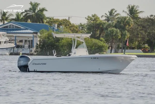 Slide: The Image of 2023 Sailfish 220 CC boat cruising on a calm waterway with a scenic background. - 2