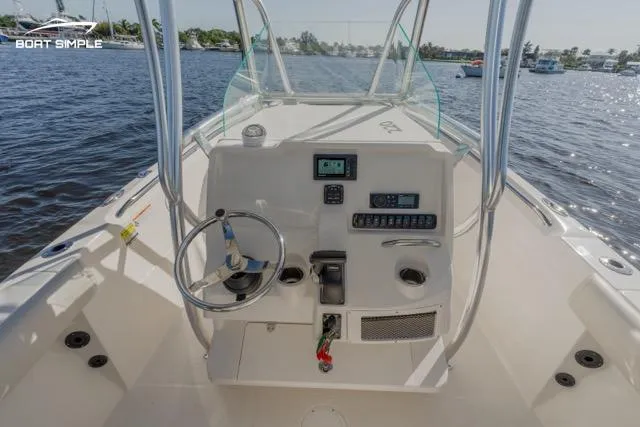 Slide: The Image of 2023 Sailfish 220 CC boat console with steering wheel and controls on the water. - 6