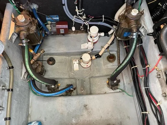 Slide: The Image of Engine compartment of a 1989 Sea Ray 390 Express Cruiser with various hoses and components. - 10