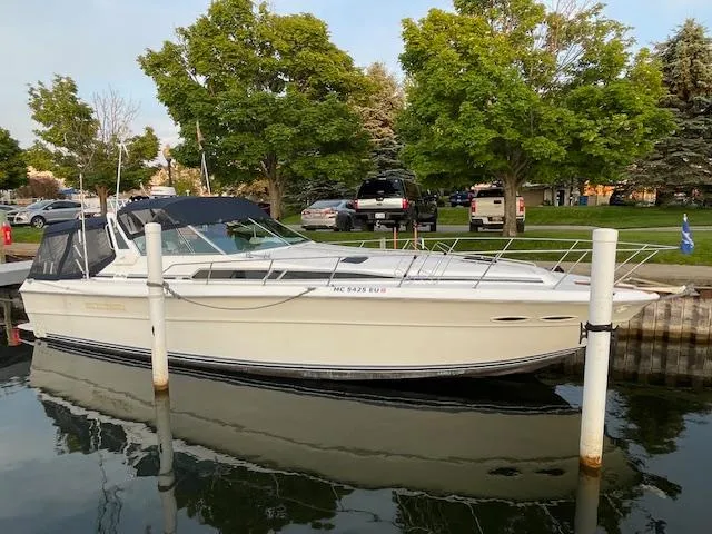 Slide: The Image of 1989 Sea Ray 390 Express Cruiser docked at a marina with trees in the background. - 2