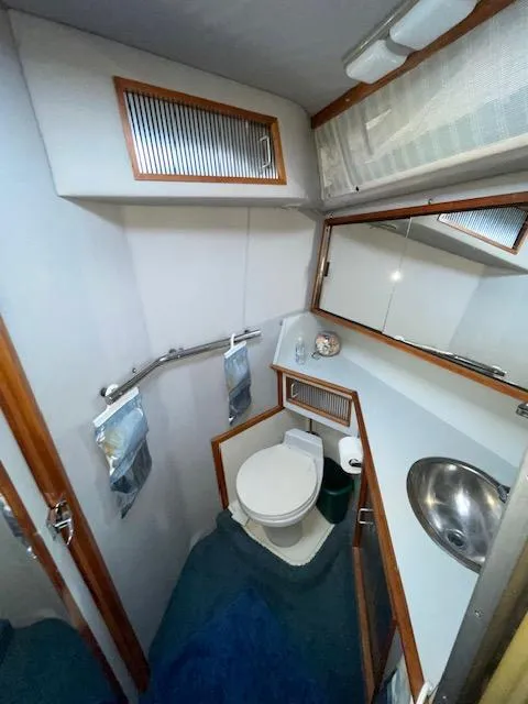 Slide: The Image of 1989 Sea Ray 390 Express Cruiser bathroom with toilet, sink, and mirror. - 23