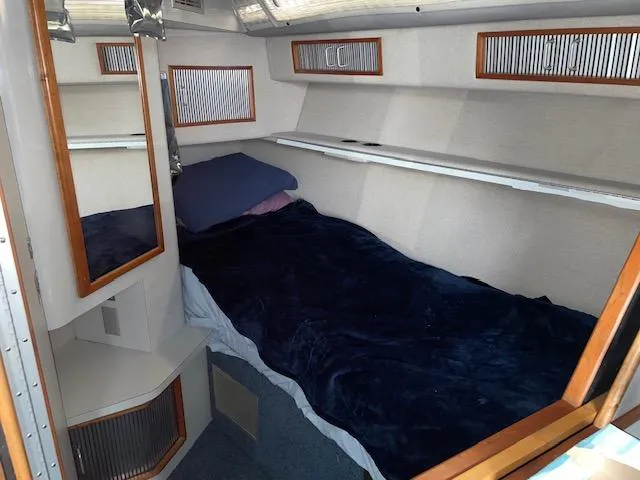 Slide: The Image of 1989 Sea Ray 390 Express Cruiser cabin interior with bed and wooden accents. - 24