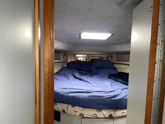 Slide: The Image of Interior cabin of 1989 Sea Ray 390 Express Cruiser with cozy bed setup. - 25