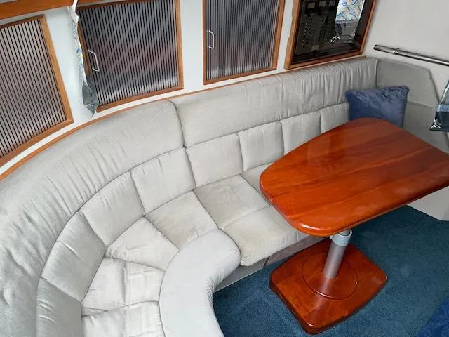 Slide: The Image of 1989 Sea Ray 390 Express Cruiser interior with curved seating and wooden table. - 26