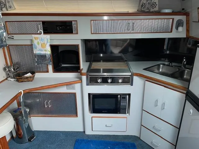 Slide: The Image of Interior kitchen of 1989 Sea Ray 390 Express Cruiser with stove, microwave, and sink. - 28